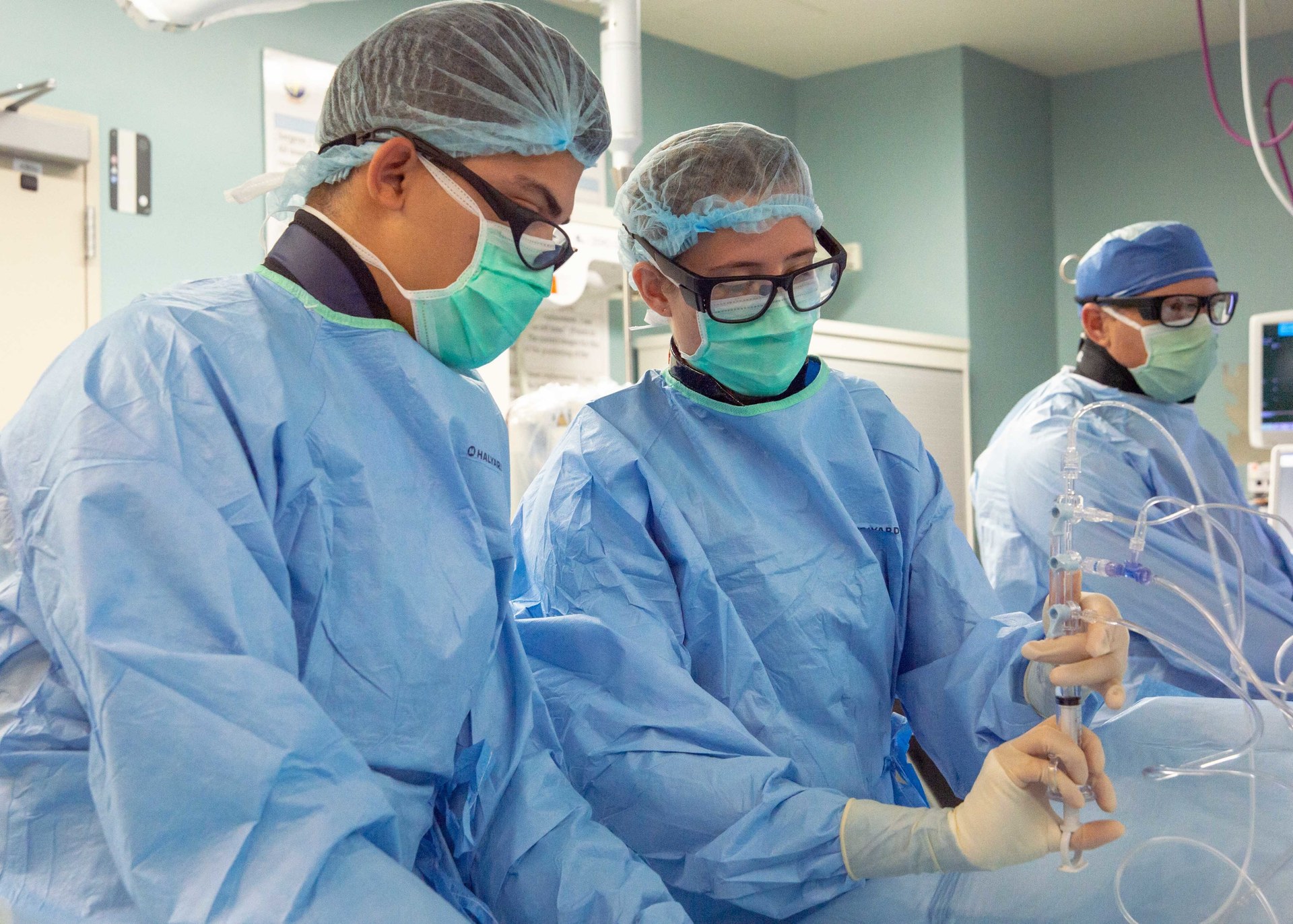 Cardiovascular technologists checking a catheterization system in a cardiac catheterization laboratory.